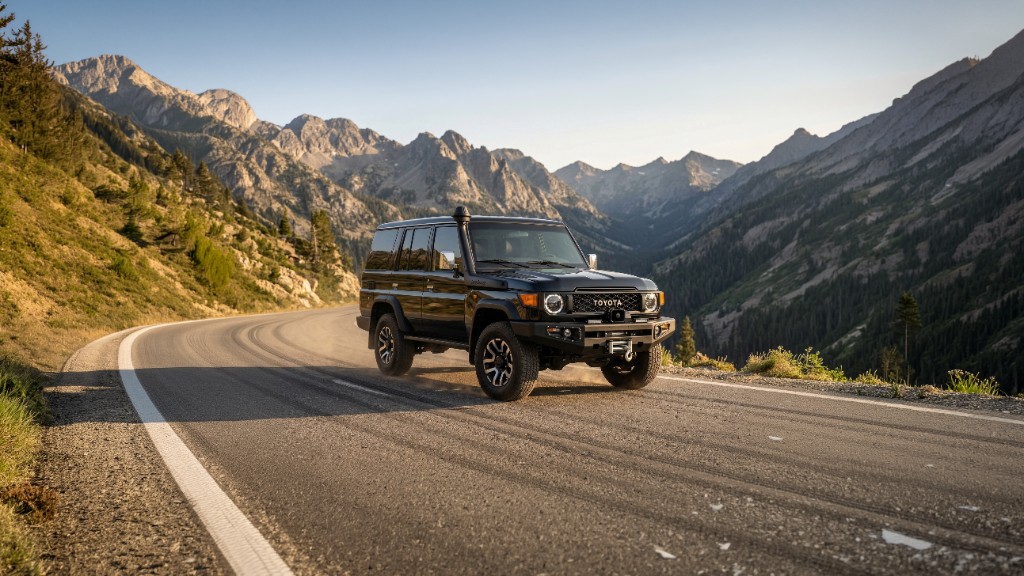 Black Toyota Hilux GR Sport driving through mud and snow in the mountains